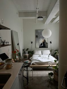 a bedroom with a bed, desk and mirror in it's center area next to a sink