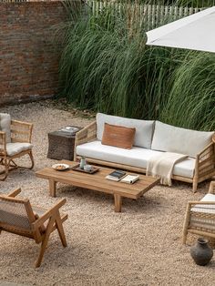 an outdoor seating area with chairs, table and umbrella