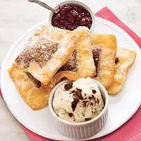 a white plate topped with pastries next to a bowl of ice cream and jelly