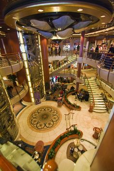 the inside of a cruise ship with stairs and escalators