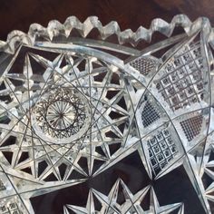 an intricately designed glass dish on a wooden table