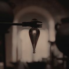 a drop of water hanging from a hook in a room filled with other items and furniture