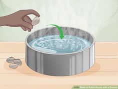 a pot filled with boiling water on top of a wooden table next to a person's hand