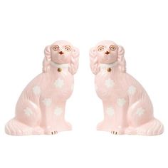 two pink dog figurines sitting next to each other