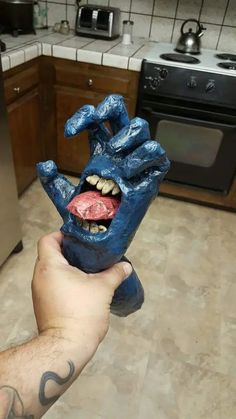 a hand holding up a blue mask in a kitchen