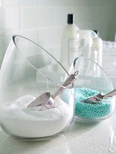 two bowls with scissors in them sitting on a counter next to blue and white powder