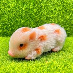 a small toy hamster sitting in the grass