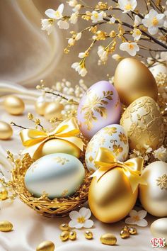 an arrangement of golden and white easter eggs in a basket on a table with flowers