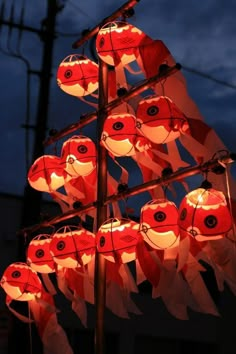 many red and white paper lanterns hanging from a pole