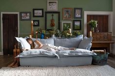 a woman laying on top of a couch in a living room