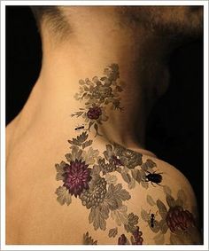 the back of a man's neck with flowers on it