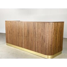 a large wooden cabinet sitting on top of a cement floor next to a white wall