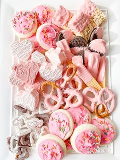 a white plate topped with lots of pink and white cookies