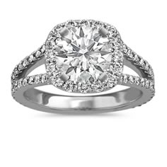 a diamond engagement ring with two rows of diamonds on the band and an oval center stone surrounded