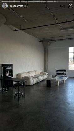 an empty room with couches and tables in it