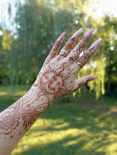 a woman's hand with hendix on it in the middle of a grassy area