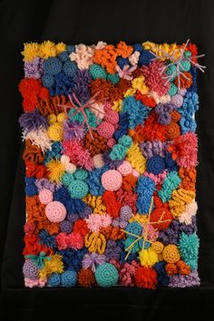 an art work made out of crochet and yarns on a black background