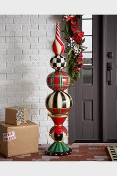 a christmas decoration on top of a pole in front of a brick wall and door