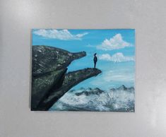 a painting of a person standing on top of a cliff