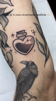 a black bird sitting on top of a person's leg next to a heart