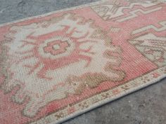 an old rug is laying on the ground with it's faded colors and patterns