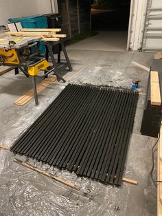 a garage filled with lots of wooden planks next to a machine and some tools