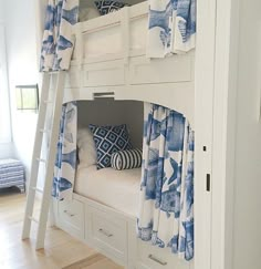 a bunk bed with blue and white curtains