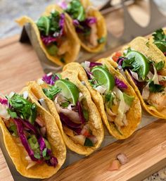 several tacos are lined up on a cutting board