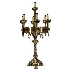 an ornate brass candelabra with candles on each candle holder, isolated against a white background