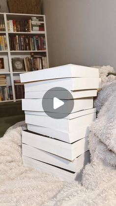 a stack of white boxes sitting on top of a bed