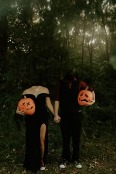 a man and woman holding pumpkins in their hands