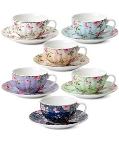 six tea cups and saucers with floral designs on the rims, all in different colors