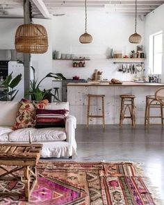 a living room filled with furniture next to a kitchen and dining area in the background