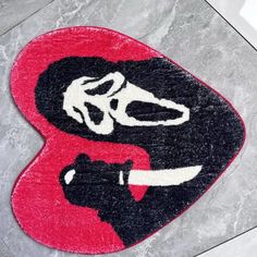 a red and black door mat with a pair of scissors on it