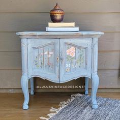 an old blue cabinet with flowers painted on it