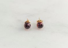 This beautiful pair of handmade stud earrings feature 2 Garnet gemstones. The stud earrings are handmade using nickel-free 14k Gold Filled or Sterling Silver. These studs are simple and dainty, perfect for everyday wear. Makes a great gift to add to any gemstone lover's collection. Perfect to gift for Christmas, Valentine's Day, Mother's Day, and more! Gemstone: Garnet Gemstone Size: 5.5 mm Metal: 14k Gold Filled or Sterling Silver (Hypoallergenic) Setting: Half Drill Earring Back: Pushback **No Ruby Necklace, January Birthstone, Garnet Earrings, Gemstone Studs, Garnet Gemstone, Gift For Christmas, Earring Backs, Birthstone, Garnet