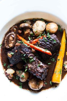 a white bowl filled with meat and vegetables