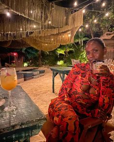 a woman sitting on a chair holding a drink