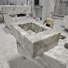 a marble sink in the middle of a room with other pieces of furniture around it