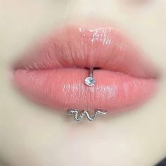 a close up view of a woman's lips with a nose ring attached to her lip