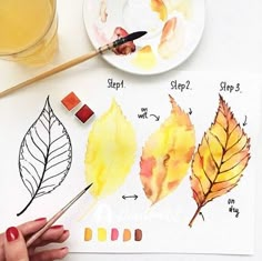 someone is painting leaves with watercolors on the paper and then using paintbrushes