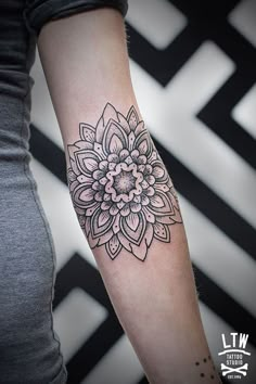 a woman's arm with a flower tattoo on it