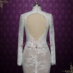 the back of a white lace dress with long sleeves and an open - back design