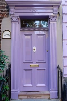 a purple front door on a brick building