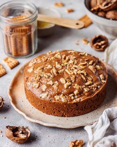 a cake sitting on top of a white plate next to nuts and other food items