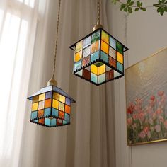 two stained glass lamps hanging from a ceiling