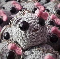 crocheted keychains with black and pink eyes are arranged in the shape of a teddy bear