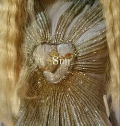 the back of a woman's head with long blonde hair and gold sequins