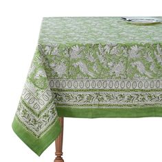 a green and white table cloth on top of a wooden table