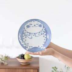 a person holding a plate with a cat on it